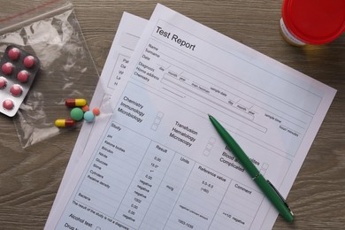 Photo of Drug test result form, pen, container with urine sample and pills on wooden table, flat lay