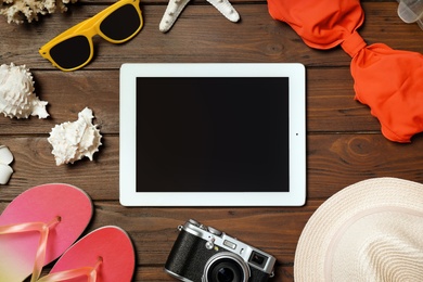 Photo of Flat lay composition with beach objects and tablet on wooden background