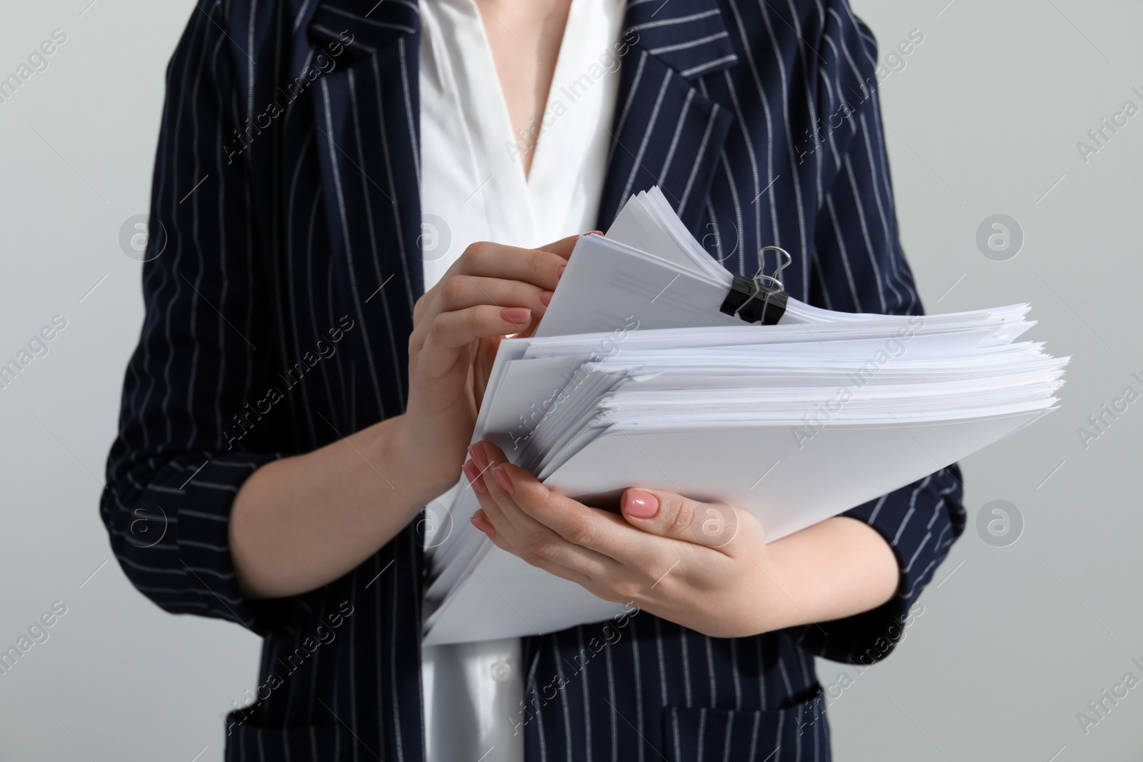 Photo of Woman stacking documents on grey background, closeup