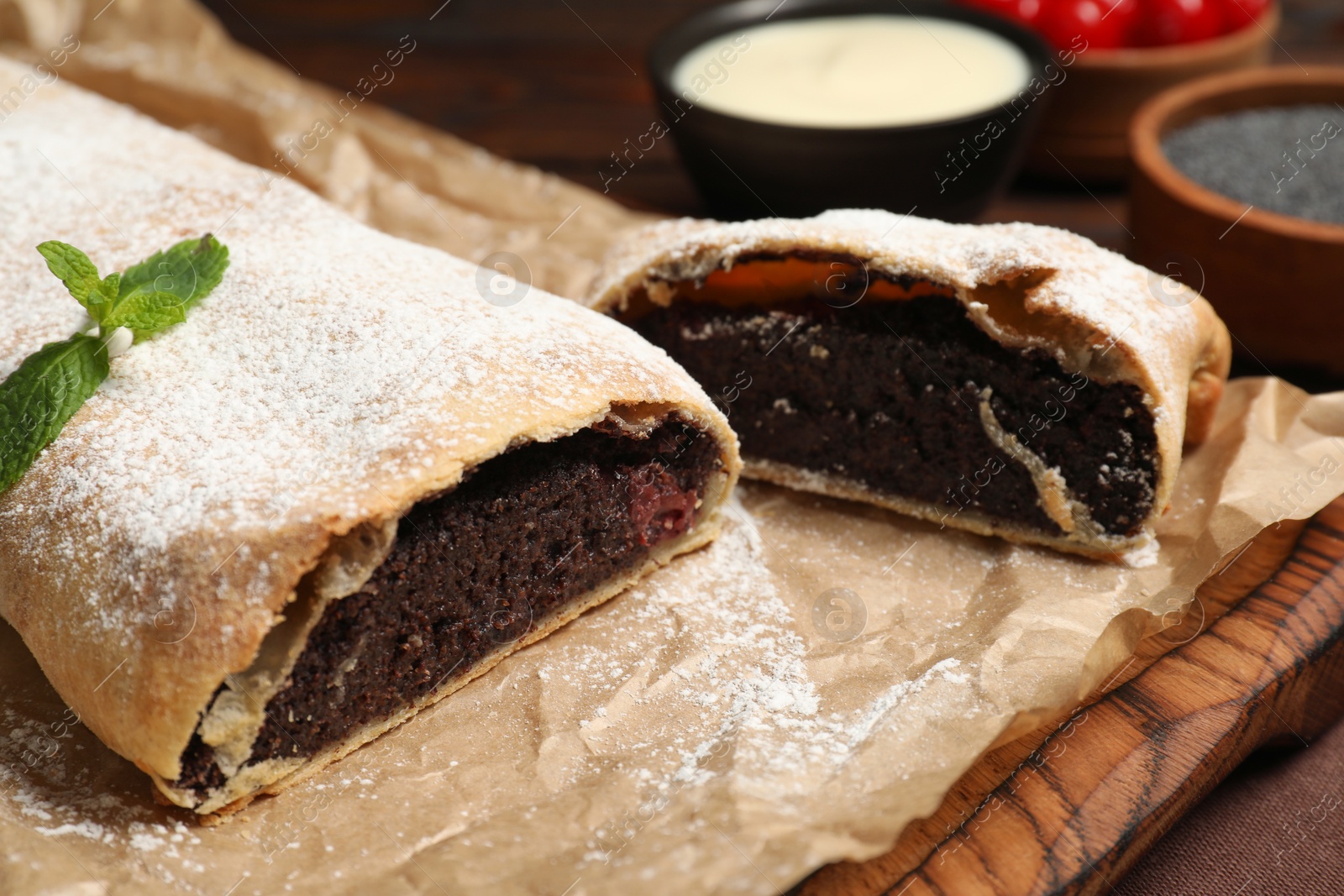 Photo of Delicious strudel with poppy seeds and cherries on board, closeup