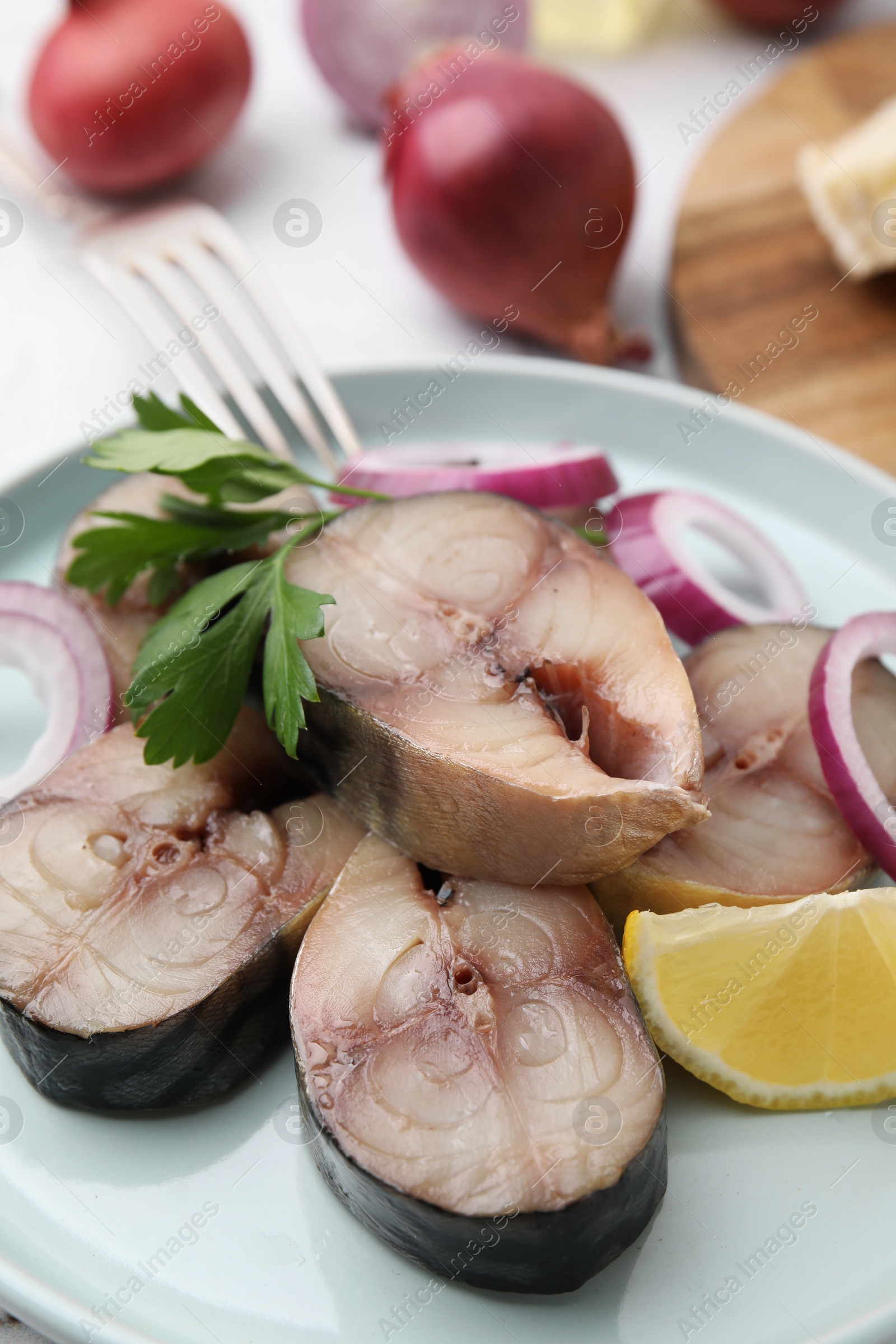 Photo of Slices of tasty salted mackerel with parsley and lemon wedge on table, closeup