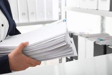 Female worker with documents in office, closeup