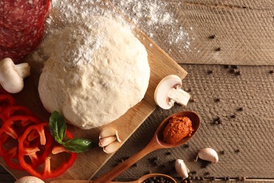 Photo of Pizza dough and products on wooden table, flat lay