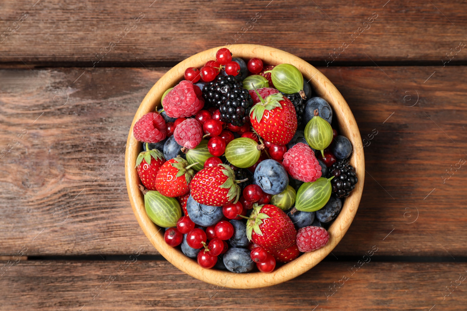 Photo of Mix of ripe berries on wooden table, top view