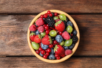 Mix of ripe berries on wooden table, top view