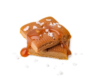 Photo of Yummy caramel candies and sea salt isolated on white