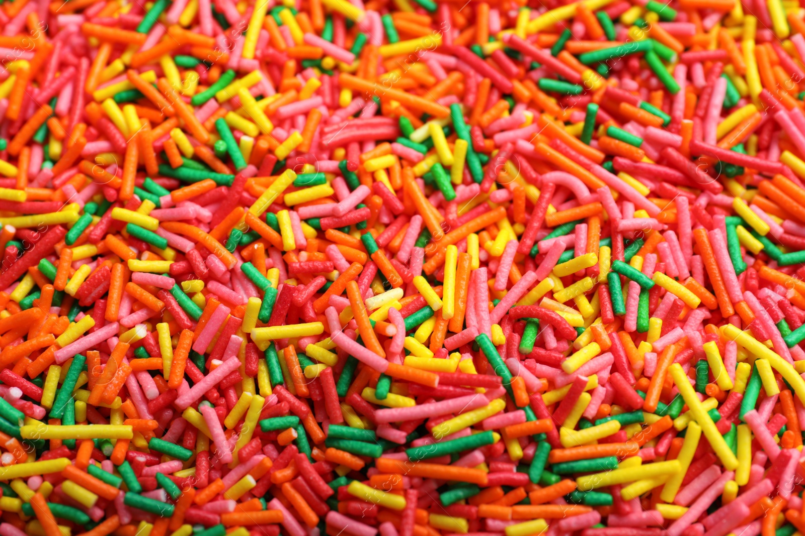 Photo of Bright colorful sprinkles as background, closeup. Confectionery decor