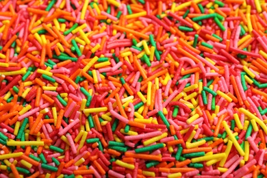 Photo of Bright colorful sprinkles as background, closeup. Confectionery decor