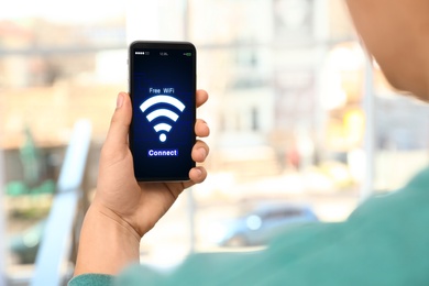 Image of Man connecting to WiFi using mobile phone, closeup
