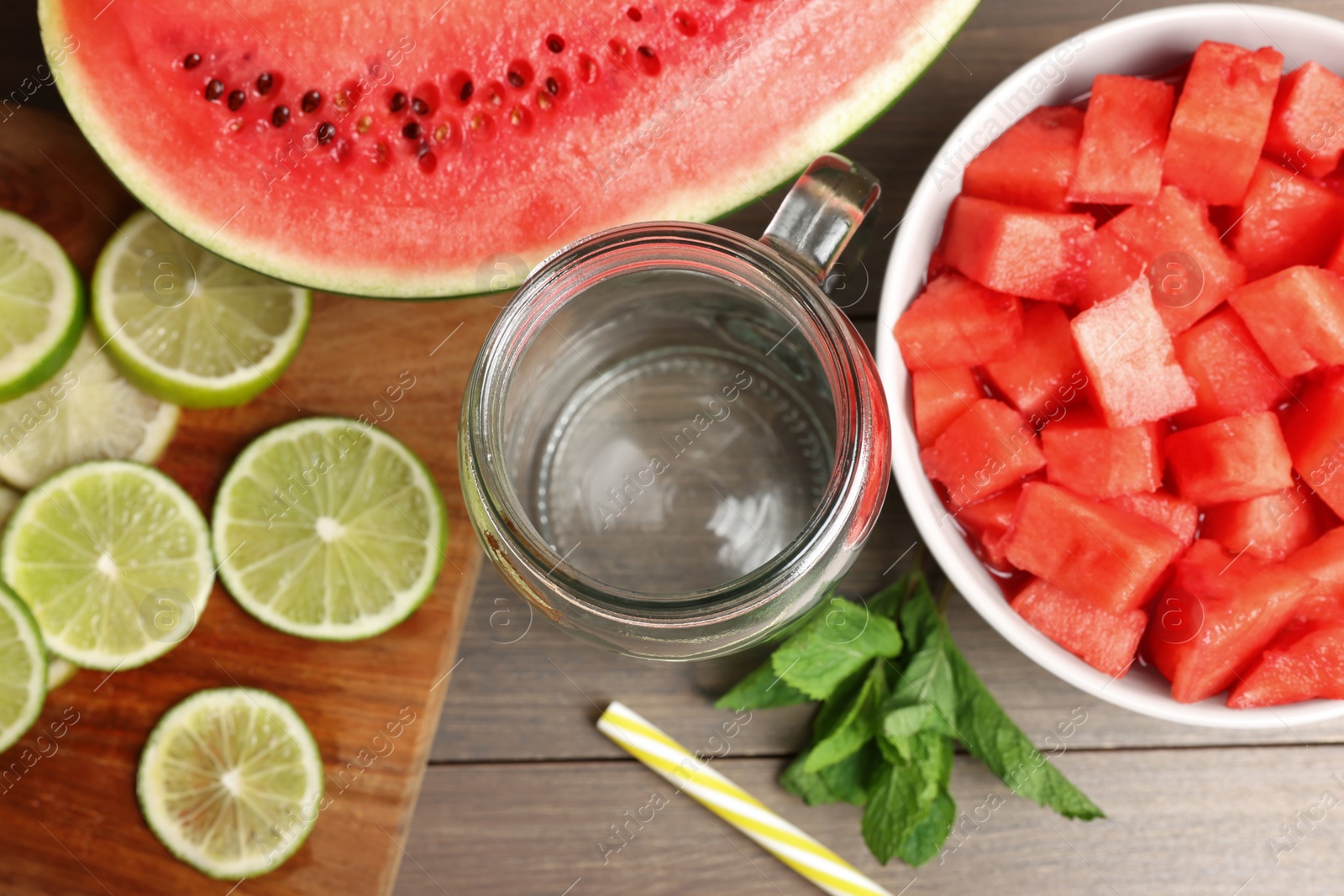 Photo of Fresh ingredients for making watermelon drink with lime on wooden table, above view