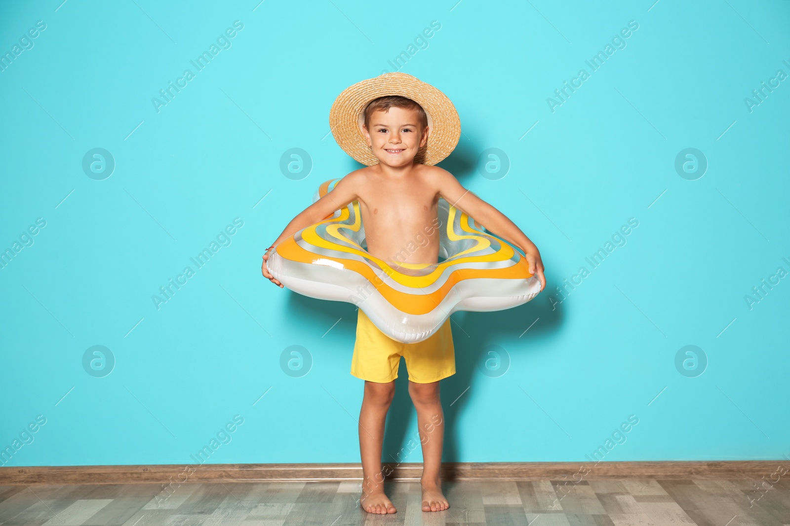 Photo of Cute little boy with inflatable star near color wall