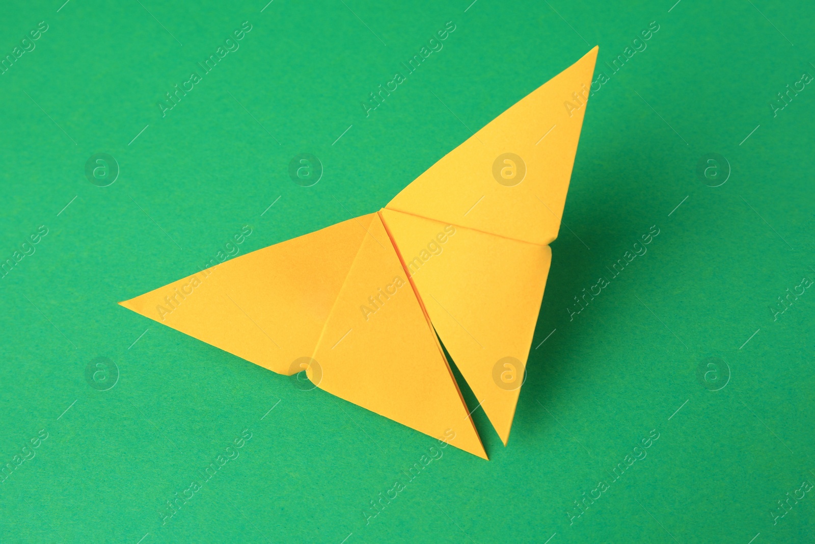 Photo of Origami art. Paper butterfly on green background