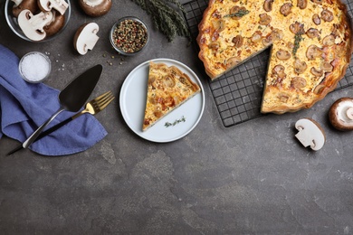 Delicious pie with mushrooms and cheese served on grey table, flat lay. Space for text