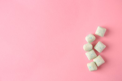 Photo of Tasty chewing gums on pink background, flat lay. Space for text