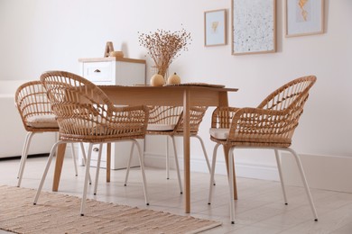 Photo of Dining room interior with wooden table and wicker chairs