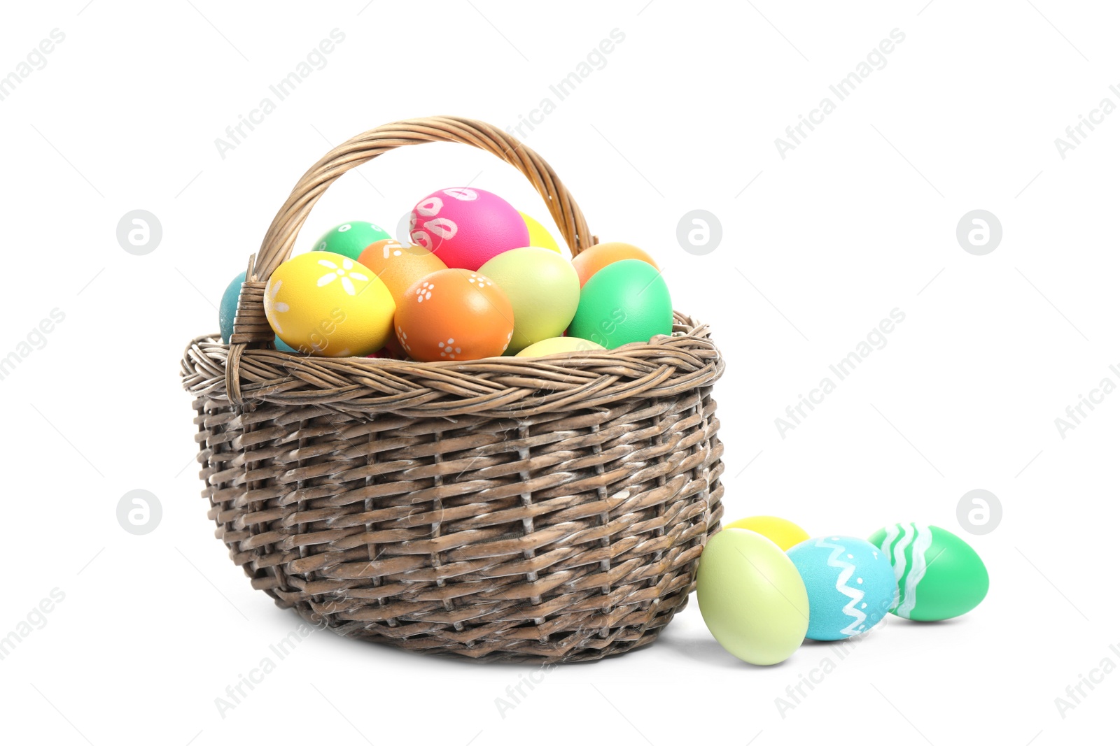 Photo of Bright Easter eggs in wicker basket isolated on white background