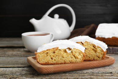 Photo of Pieces of homemade yogurt cake with cream on wooden table