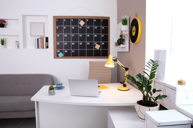 Photo of Stylish workplace interior with laptop on table