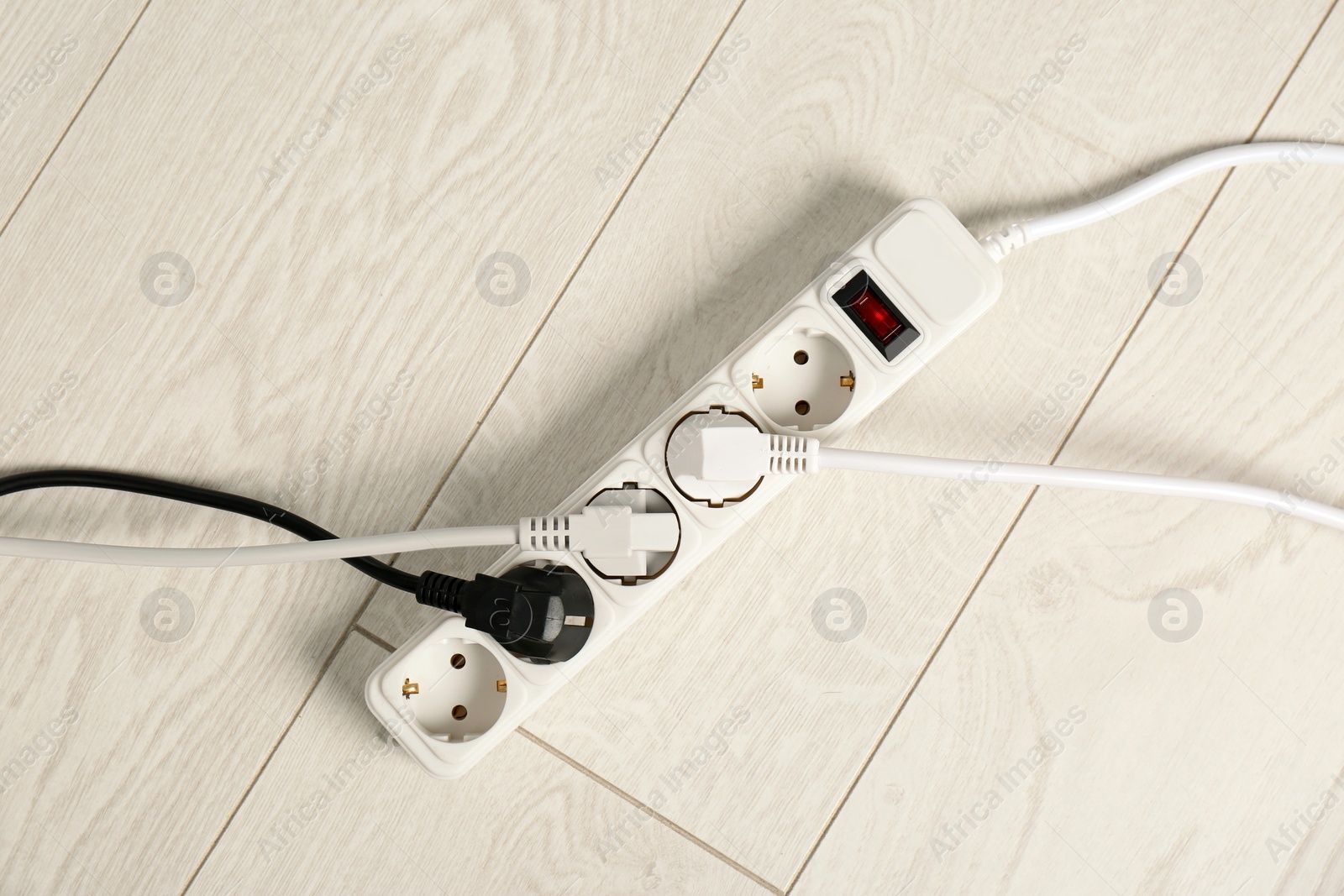 Photo of Extension cord on floor, top view. Electrician's professional equipment