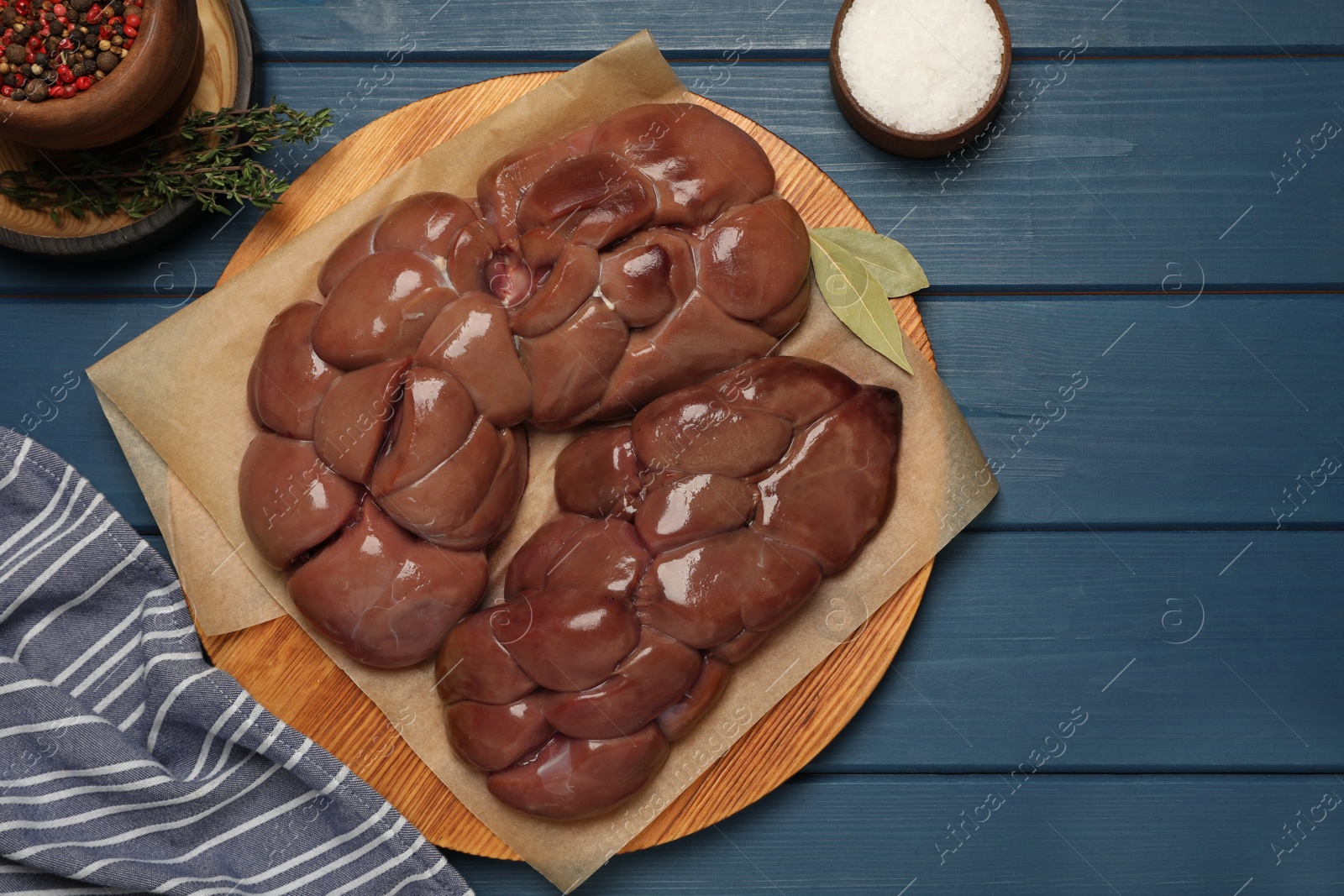 Photo of Fresh raw kidney meat, spices and thyme on blue wooden table, flat lay