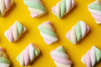 Photo of Delicious colorful marshmallows on yellow background, flat lay