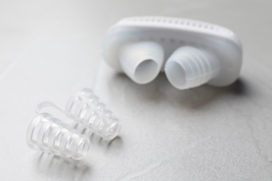 Photo of Different anti-snoring devices for nose on grey table