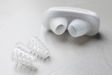 Different anti-snoring devices for nose on grey table