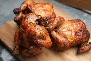 Photo of Delicious grilled whole chickens on grey table, closeup