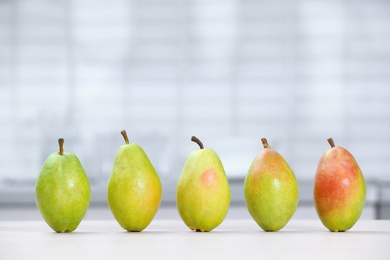 Fresh ripe pears on white table in kitchen. Space for text