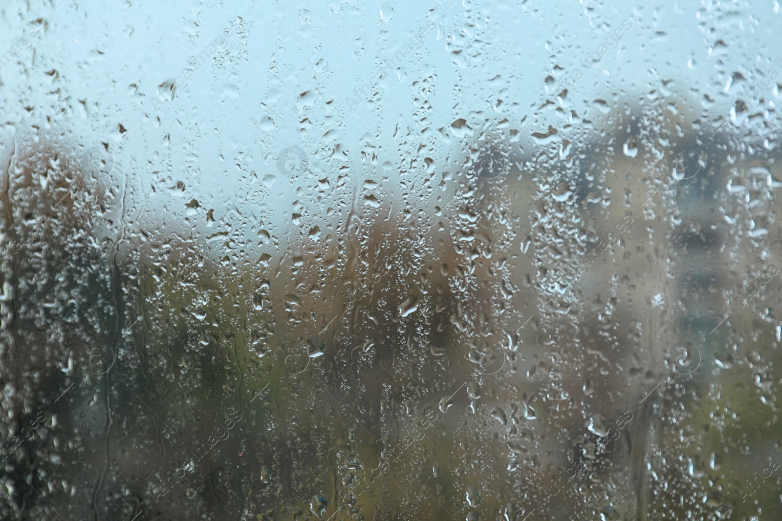 Photo of Rain drops on window glass as background, closeup