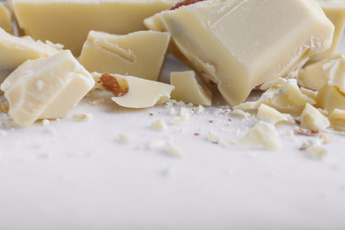 Photo of Pieces of white chocolate with nuts on light table