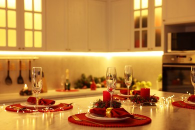 Photo of Christmas table setting with festive decor in kitchen