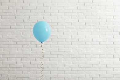 Photo of Bright balloon near brick wall, space for text. Celebration time