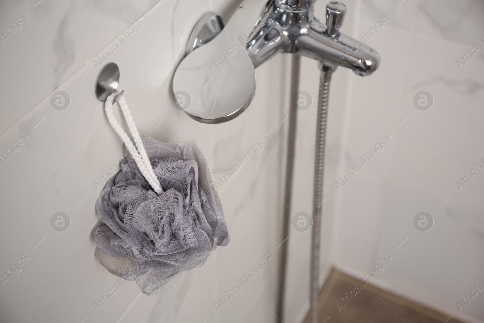 Photo of Grey shower puff hanging near faucet in bathroom, above view