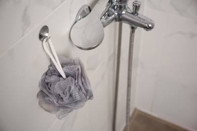 Grey shower puff hanging near faucet in bathroom, above view