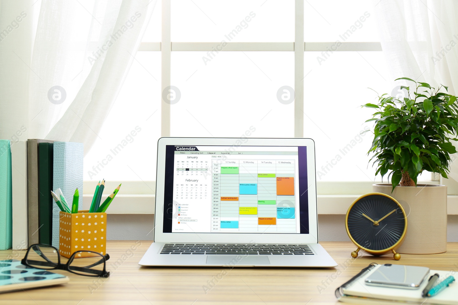 Photo of Modern laptop with calendar on screen in office