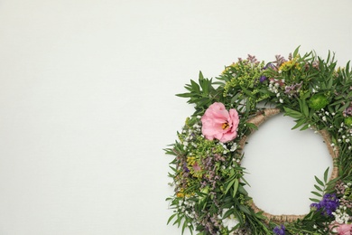 Photo of Wreath made of beautiful flowers on white background, top view. Space for text
