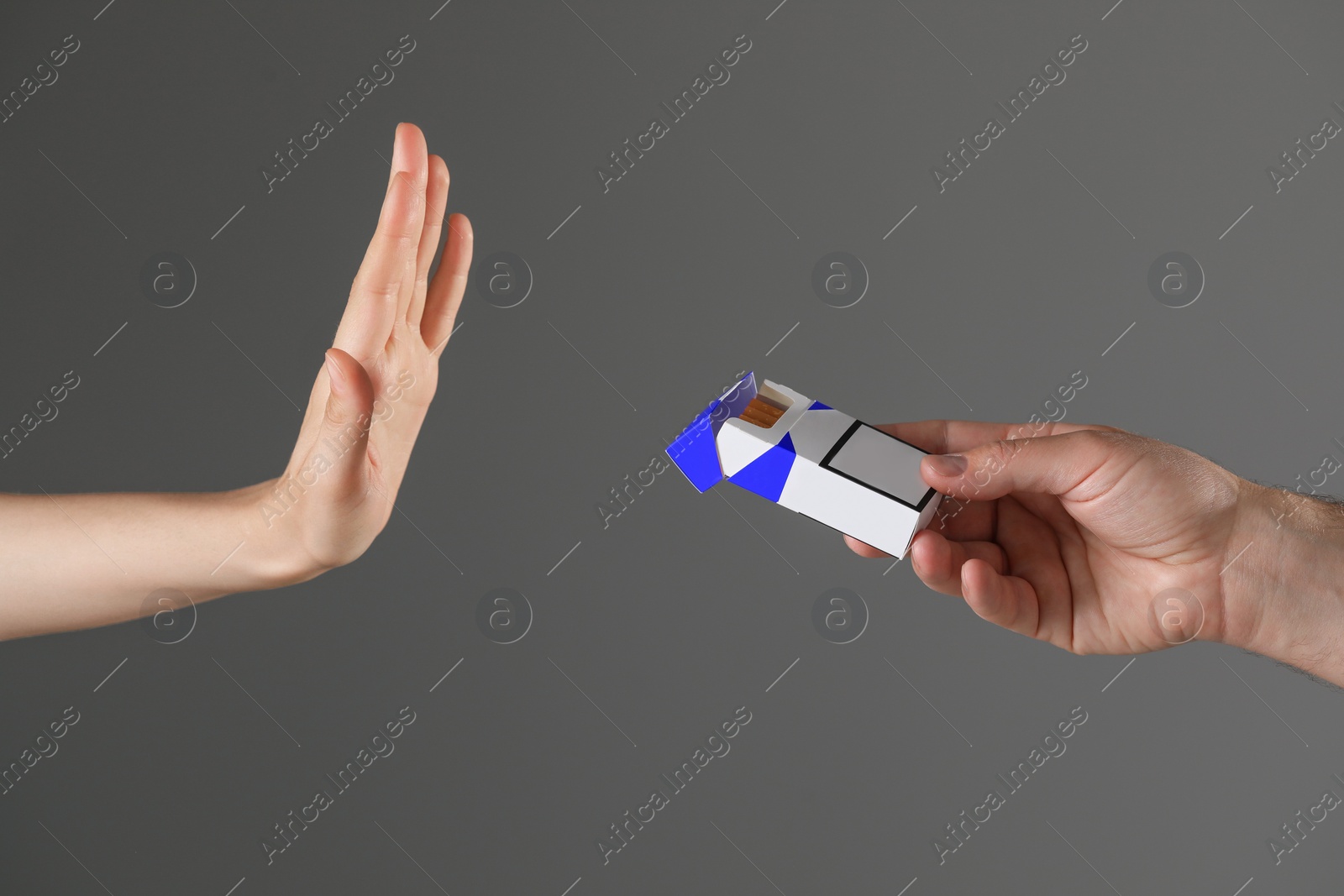 Photo of Stop smoking concept. Woman refusing cigarettes on gray background, closeup