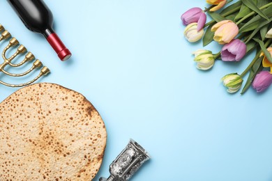 Photo of Flat lay composition with matzo on light blue background, space for text. Passover (Pesach) celebration