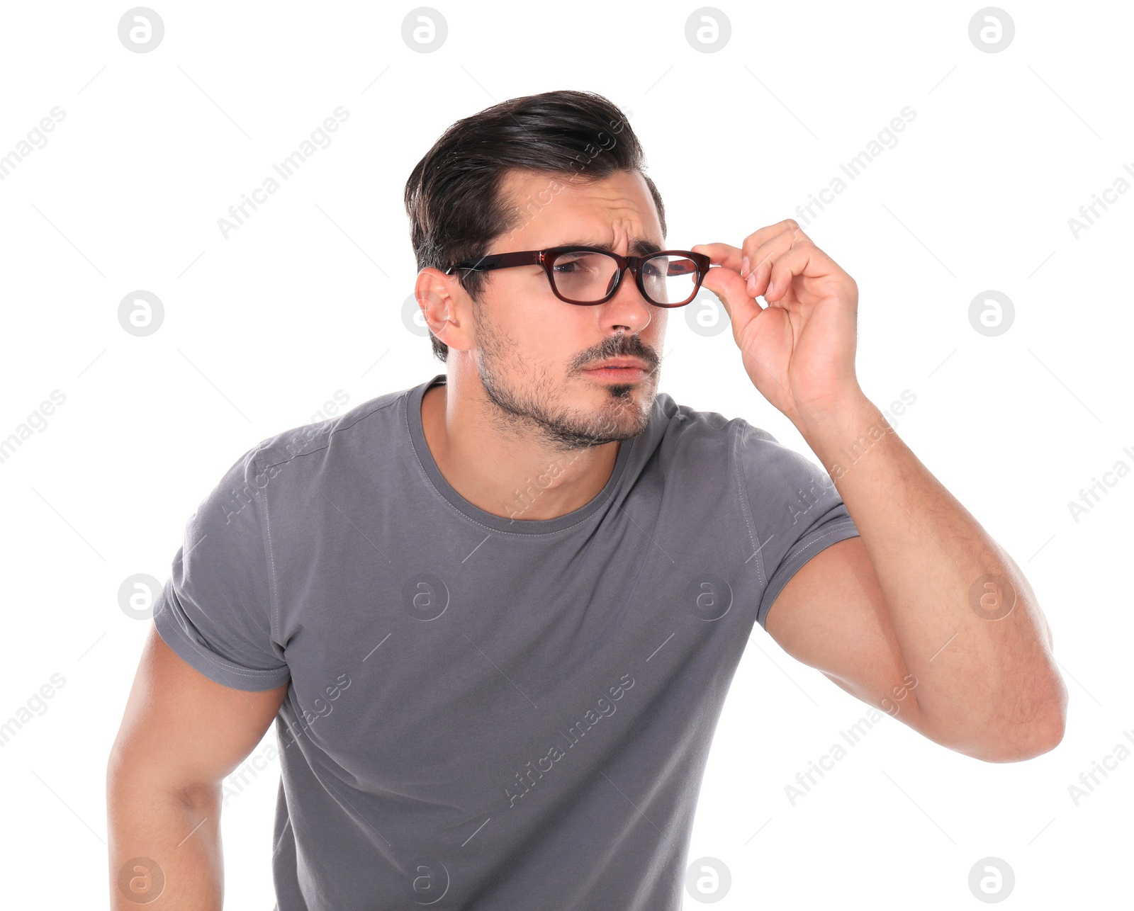 Photo of Young man with vision problem wearing glasses on white background