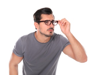Photo of Young man with vision problem wearing glasses on white background