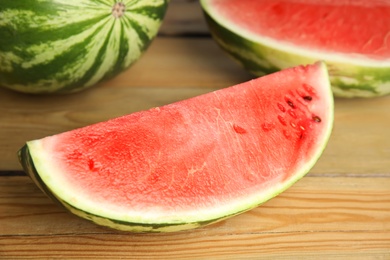 Photo of Yummy watermelon slice on wooden table, closeup