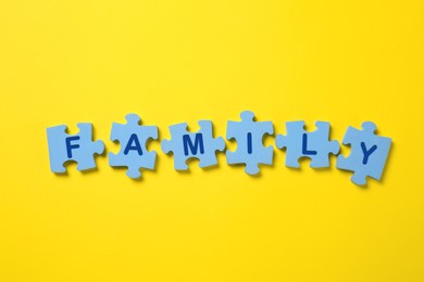 Word Family made of puzzles with letters on yellow background, flat lay