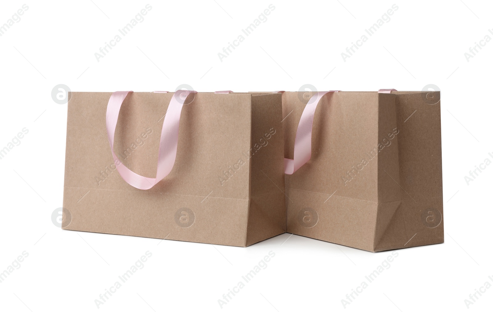 Photo of Paper shopping bags with ribbon handles on white background. Mockup for design