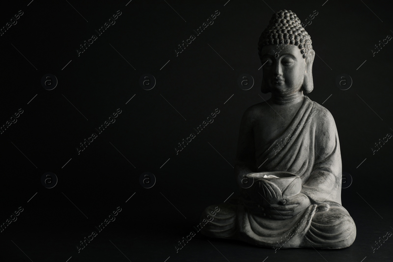 Photo of Beautiful stone Buddha sculpture on black background. Space for text