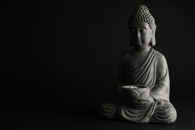 Photo of Beautiful stone Buddha sculpture on black background. Space for text