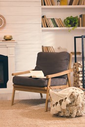 Cozy living room interior with comfortable armchair near fireplace