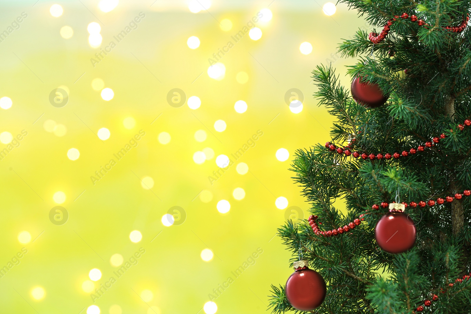 Photo of Decorated Christmas tree against blurred lights on background, space for text. Bokeh effect