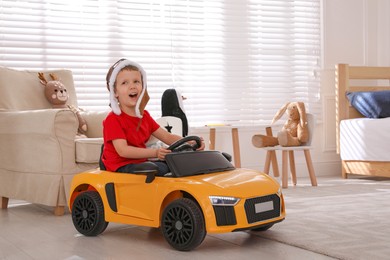 Little child playing with toy car in room