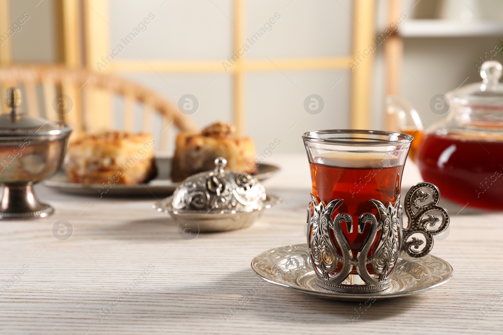 Photo of Traditional Turkish tea and sweets served in vintage tea set on white wooden table. Space for text